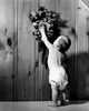Poster print of a rear view of a baby boy reaching for a cuckoo clock.