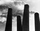 Low angle view of smoke stacks poster print showcasing industrial beauty.