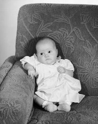 High angle view of a baby girl sitting on a couch poster print.