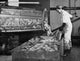 Mid adult man scaling and washing fish using a revolving drum poster print.