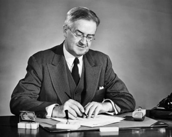 Businessman writing on paper and smiling poster print