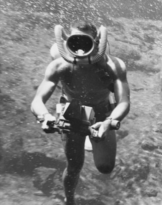 Scuba diver holding an underwater camera in the sea poster print.