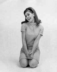 Portrait of a young woman kneeling on the floor and smiling poster print