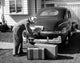 Man loading luggage into car trunk poster print