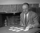 Man laying cards on table poster print, capturing suspenseful moment.