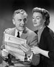 Senior couple holding a bill, poster print showing companionship and financial responsibility.