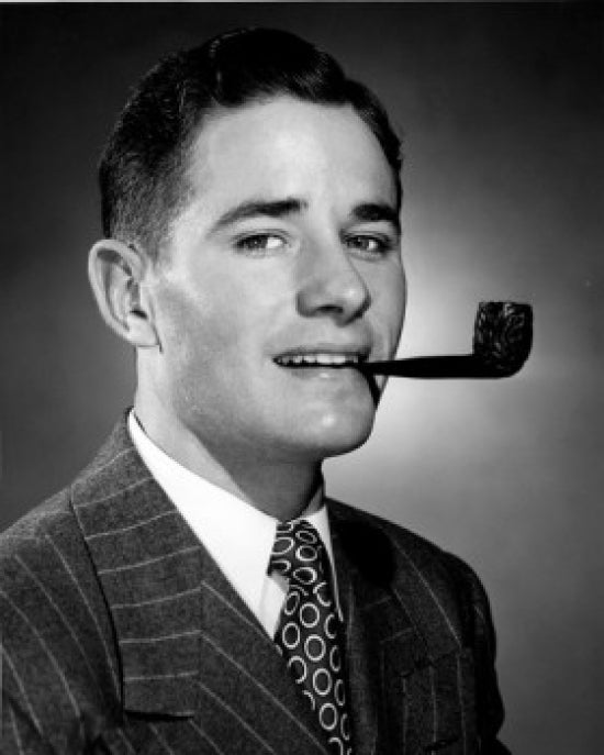 Studio portrait of a young man smoking a tobacco pipe, vintage art print.