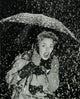 Young women holding an umbrella in the snow poster print