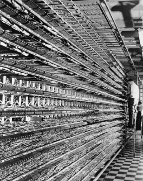 Technicians working on a distributing frame in a telephone network control room poster print