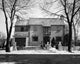 Facade of a House in Winter Poster Print showcasing a cozy winter scene.