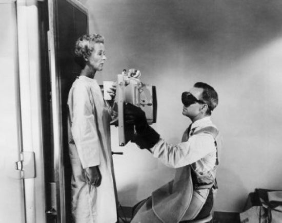 Side profile of a male radiologist taking an x-ray of a female patient poster print.