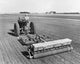 Poster print featuring a farmer sowing alfalfa and ladino clover seeds in a field.