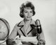 Mid adult woman reading a report into a microphone poster print