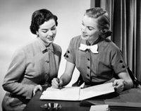 Close-up of two businesswomen discussing in an office poster print.