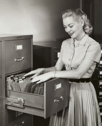 Businesswoman Searching for Files in a Filing Cabinet Poster Print