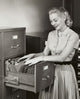 Businesswoman Searching for Files in a Filing Cabinet Poster Print