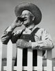 Close-up of a senior man standing near a picket fence poster print.