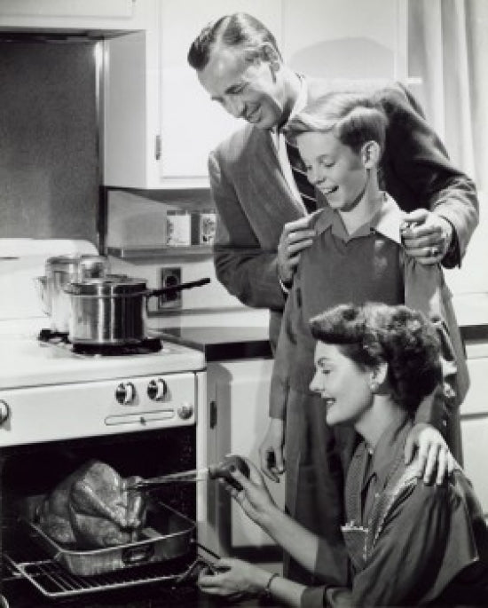 Parents and their son preparing a turkey in the kitchen poster print