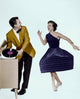 Young man holding a record while looking at a dancing woman, vibrant poster print.