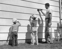 Poster print of a mature man with his two sons painting a wall together.