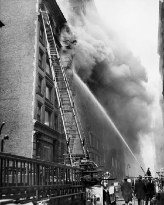 Firefighters spraying water on a burning building - low angle view poster print.