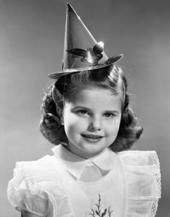 Portrait of a girl wearing a birthday hat, smiling, colorful print.