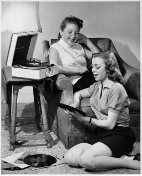 Two teenage girls enjoying music poster print for home decor.