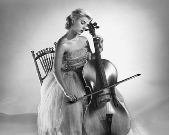 Young woman sitting on a chair playing a cello poster print.
