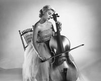 Young woman sitting on a chair playing a cello poster print.