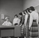 Teenage girls standing beside a nurse's desk poster print.