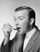 Close-up of a mid adult man taking medicine from a spoon poster print