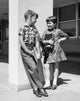 Poster print of a boy and girl carrying books and talking to each other.