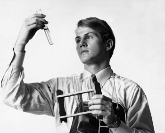 Male scientist examining chemical in a test tube poster print.