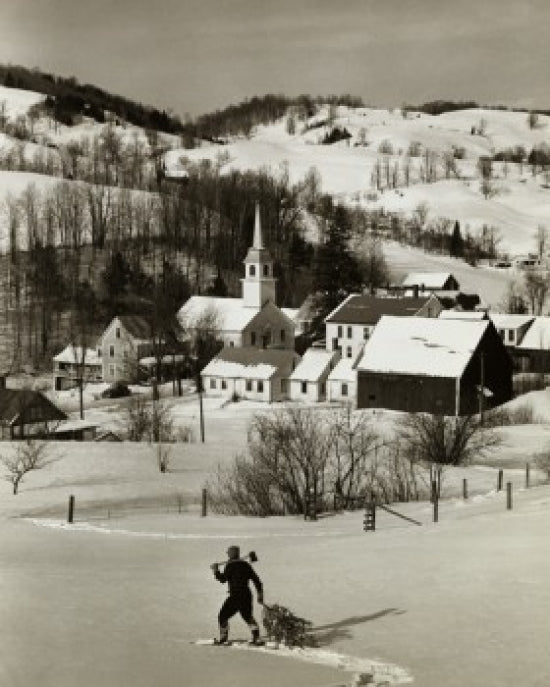 High angle view of a man pulling a Christmas tree in snow-covered landscape poster print.