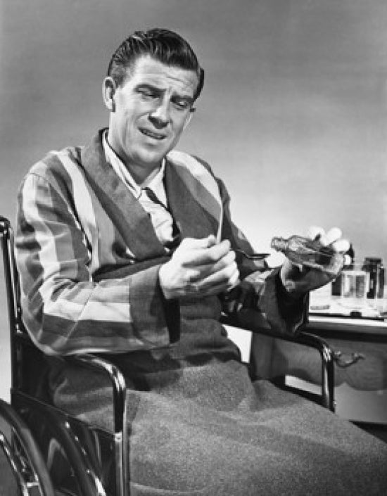 Mature man in wheelchair pouring medicine into a spoon poster print.