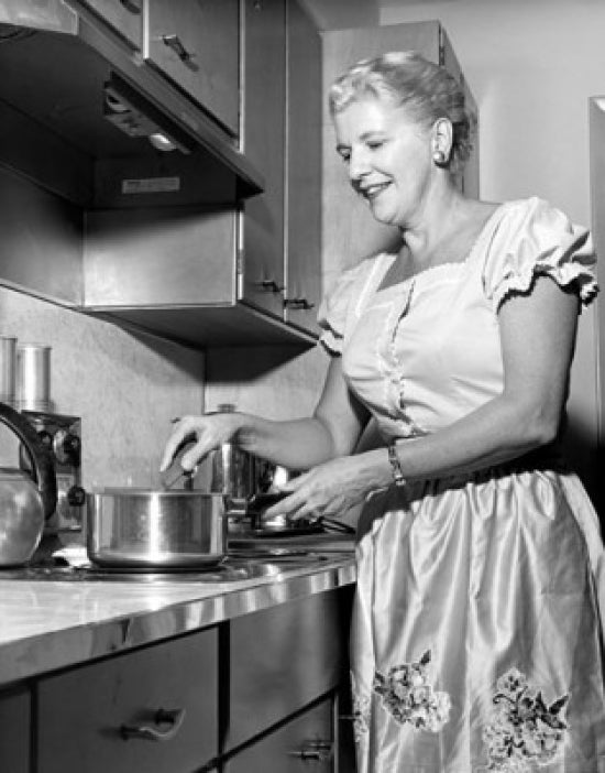 Mid adult woman preparing food in a domestic kitchen poster print.