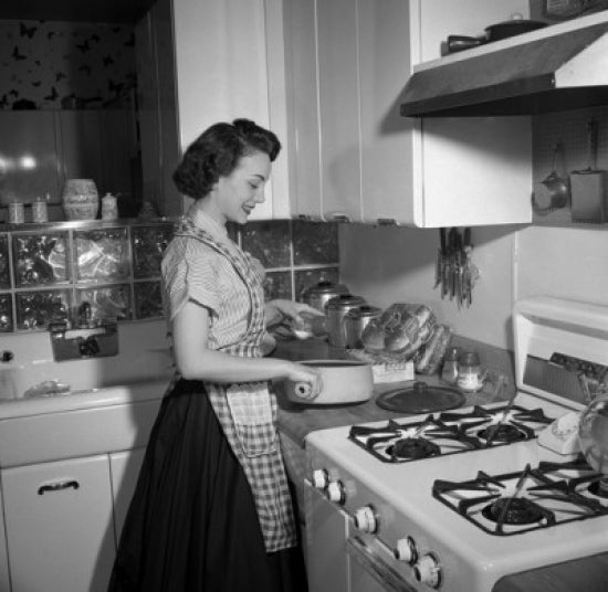 Young Woman Cooking in Kitchen Poster Print showcasing a warm kitchen atmosphere.