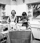 Poster print of two teenage girls preparing food in the kitchen.