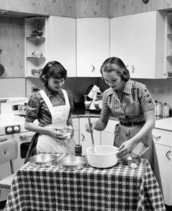 Two Young Women Cooking Poster Print showcasing a vibrant cooking scene.