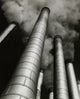 Low angle view of smoke stacks poster print showcasing industrial beauty.
