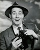 Portrait of a young man smiling while holding binoculars poster print