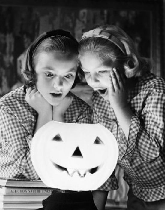 Close-up poster of two girls looking at an illuminated jack o' lantern.