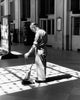 Senior man sweeping a floor poster print
