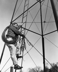 Electrician climbing on an electricity pylon poster print