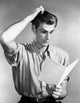 Poster print of a young man reading a newspaper, showcasing a thoughtful expression.