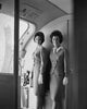 Two flight attendants smiling on an airplane poster print