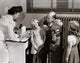 Male doctor examining a girl's ear with an otoscope poster print