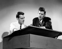 Low angle view of two architects discussing a blueprint.