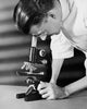Close-up of a scientist looking through a microscope poster print.