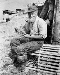 Portrait of a fisherman sitting on a lobster trap holding a fishing net poster print.